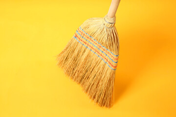 Wall Mural - One corn straw broom on yellow background