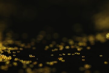 Poster - Beautiful shiny golden glitter on black background, closeup