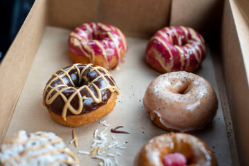 Glazed donuts in a box with different toppings