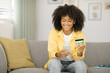 © Home-stock - Positive black lady shopping online with cellphone and credit card, making internet purchases from home, free space