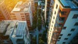 © kitidach - Aerial view of modern apartment buildings with solar panels, surrounded by greenery and bathed in warm sunset light.