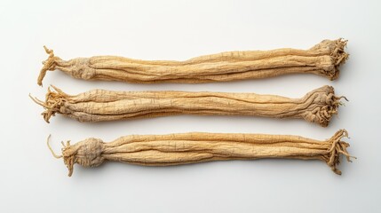 Group of dried ginseng roots isolated on a white surface, captured from above. The simplicity of the background highlights the organic texture and detail