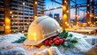 © Sirinporn - Festive hard hat adorned with holly and lights rests on a pile of construction materials amidst a snow-covered building site during the holiday season.