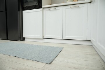 Poster - Stylish soft rug on wooden floor in kitchen