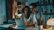 © VK Studio - A couple working at a desk at home, illuminated by a lamp, deeply focused on their laptops amidst a cozy evening setting.