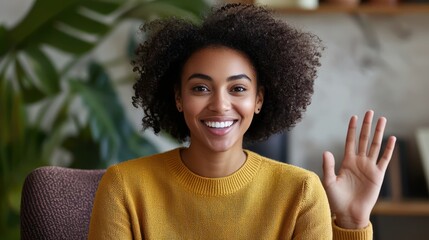 A person making a video call, smiling and waving as they introduce themselves to a new group or audience.