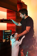 © Luciano Spinelli/Stocksy - Man play vinyl record and pet his dog next to wood vintage shelf