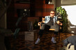© Luciano Spinelli/Stocksy - Portrait of seated artist in sunglasses enjoy sunset and play with dog
