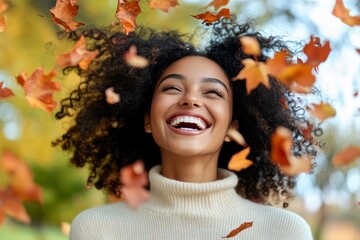 Wall Mural - A girl laughs as she throws leaves in the air in an autumn park