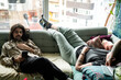 © Jenny Jungle/Stocksy - Two young people resting on couch