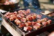 © Victor Bertrand - Juicy, diced meat sizzles on a hot grill at an outdoor barbecue, smoke wafting up as the cubes are perfectly charred and ready to be savored.