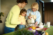 © Iuliia Versta/Stocksy - Cheerful kid girl helping granny and mom to bake in home kitchen