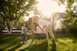 © Iuliia Versta/Stocksy - family playing on a backyard