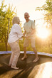 © Iuliia Versta/Stocksy - a senior couple jumps on a trampoline