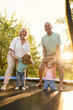 © Iuliia Versta/Stocksy - a senior couple with two grandchildren jumping on a trampoline