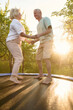 © Iuliia Versta/Stocksy - a senior couple jumps on a trampoline