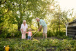 © Iuliia Versta/Stocksy - Little girl working with her grandparents in the garden