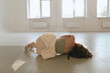 © Serge Filimonov/Stocksy - Lonely woman lying on floor and embrace herself
