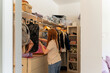 © Eloisa Ramos/Stocksy - Sorting Clothes in Closet