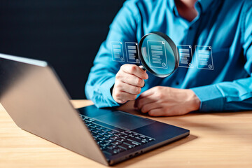 software, secure, code, page, analysis, magnifier, magnifying glass, search, research, find. A man is holding a magnifying glass. The laptop screen shows a document with a magnified view of the text.