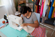 © mahalo studio/Stocksy - seamstress sewing fabric with sewing machine at home