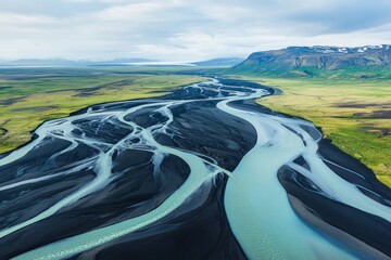 Aerial view of the Icelandic glacial river system, with dark black sand and aquamarine water