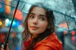 © jessica - young woman wearing a bright red raincoat, standing under a clear umbrella in a light drizzle