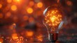 © Рудой Максим - Glowing light bulb with sparkling filament illuminated against a blurred warm background