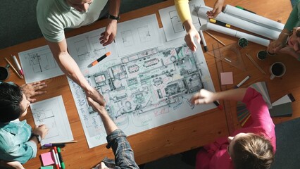 Top down view of smart business people shaking hands and making a contract. Aerial view of architect engineer working together and dealing plan or project at table with blueprint and notes. Symposium.