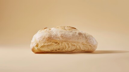 A ciabatta loaf on an isolated light beige background