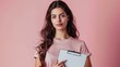 © CreativeSeven  - Confident Young Woman Holding Clipboard Against Pink Background for Business or Education Concept
