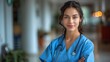 © Рудой Максим - A confident young medical professional wearing scrubs and a stethoscope poses in a bright hospital corridor during a busy day