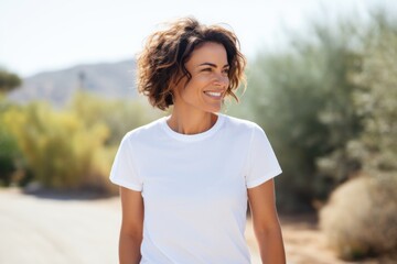 Smiling happy middle aged Caucasian woman wearing white t shirt outdoors