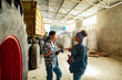 © Marko Geber - Two female farmers talking in warehouse next to truck