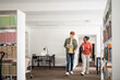 © Hernandez & Sorokina/Stocksy - Two students conversation while walking in library