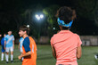 © Hugo Fuentes/Stocksy - Female football coach looking at the field.