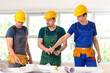 © Pixel-Shot - Team of male builders working with house plan in room