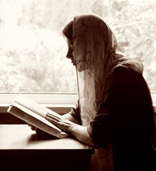 Wall Mural - Girl reading a book by the window