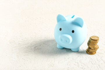 Wall Mural - Piggy bank with coins on textured white background