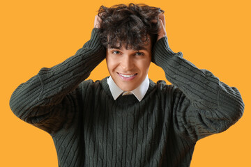 Wall Mural - Portrait of young man suffering from headache on orange background