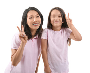 Poster - Asian mother with her little daughter showing victory gesture on white background