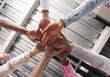© Daniel Zapata/Stocksy - Multiracial people stacking hands.