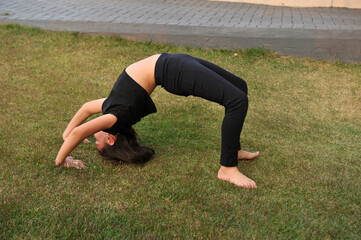 menina fazendo exercicios ponte na grama 