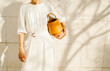 © Ulas&Merve/Stocksy - Woman in Stylish White Dress Holding Yellow Handbag