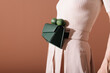 © Ulas&Merve/Stocksy - Stylish Woman Wearing Green Handbag With Limes On Belt