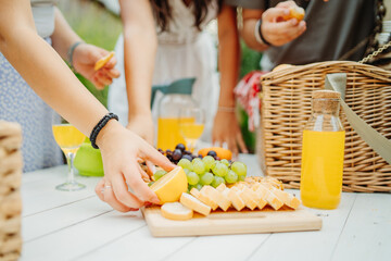 Group of three friends or family having picnic in backyard or garden