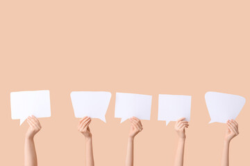 Wall Mural - Female hands with speech bubbles on brown background