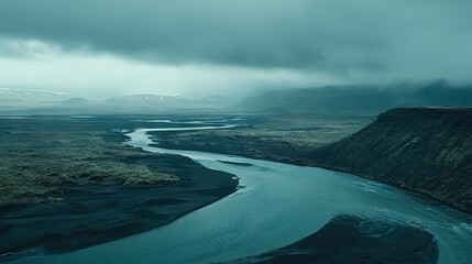 Poster -   A river flows through a verdant valley beneath a cloudy sky, surrounded by majestic mountains and a distant mountain range