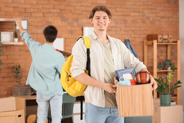 Poster - Male student with box in dorm room on moving day