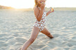 © Tarık Kızılkaya/Stocksy - Little girl playing on the sand, eating some snack, chips.